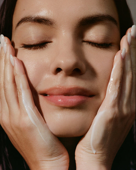 Close-up of a woman with hands on either side of their face, with a focus on skincare.