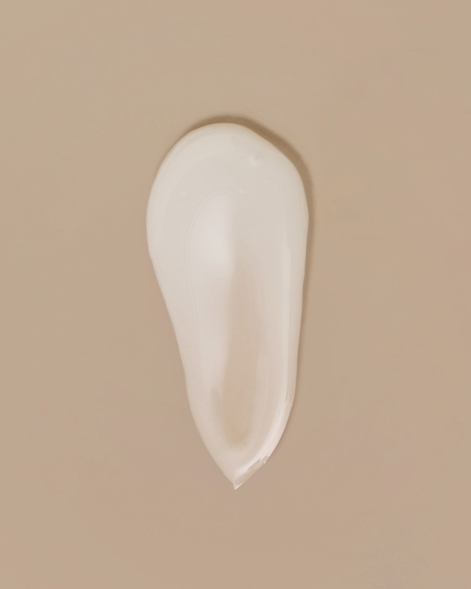 White serum smear on a beige background