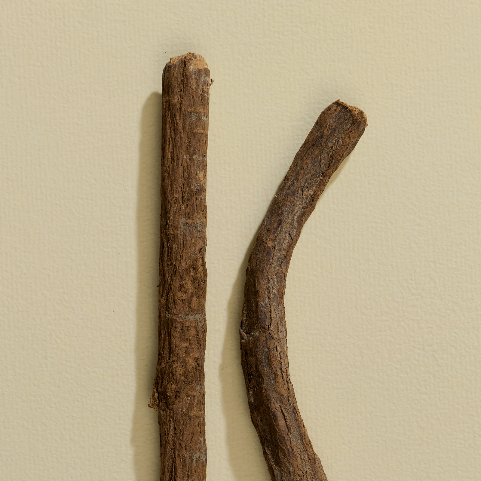 Two sticks of different lengths on a beige background