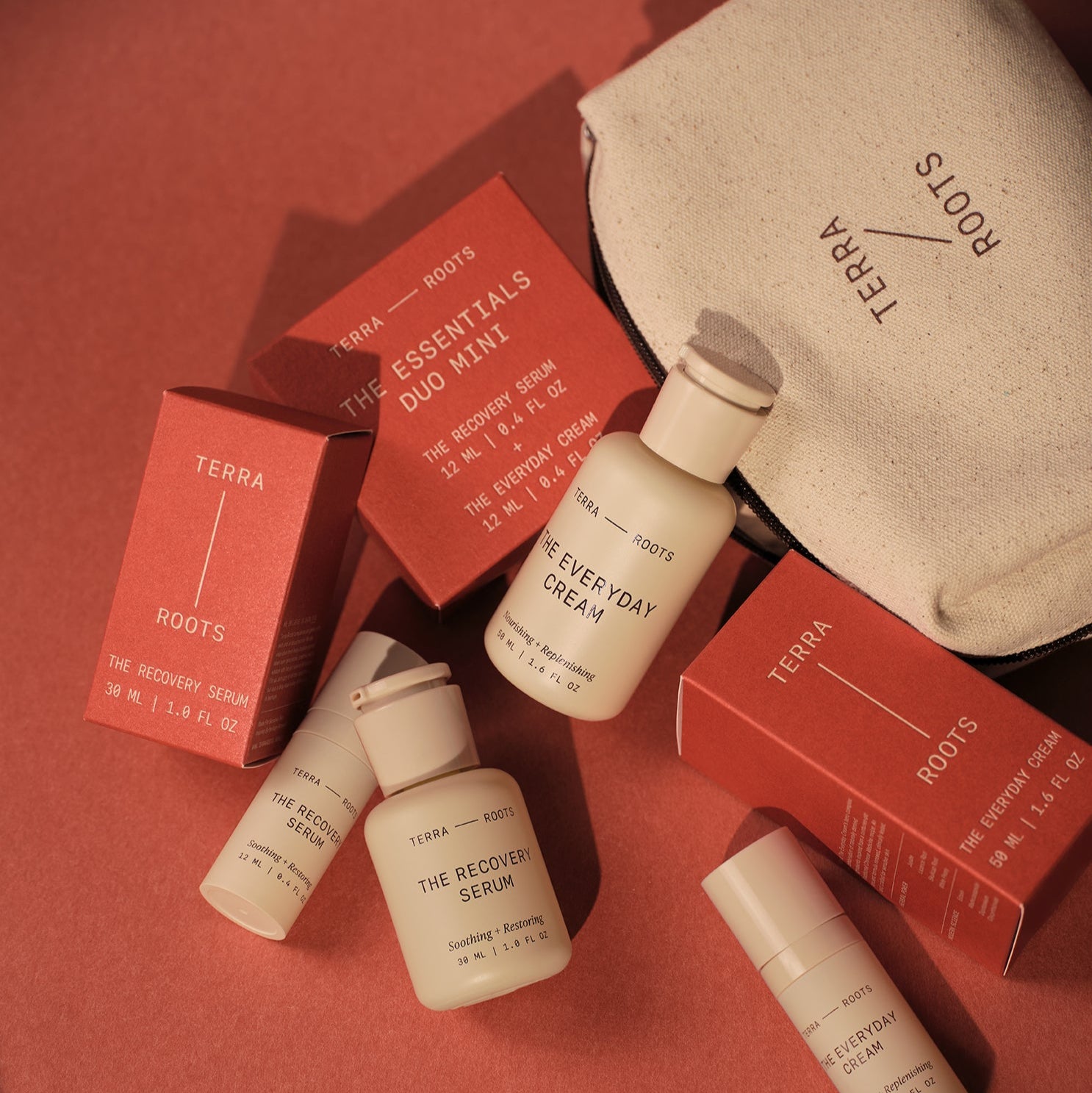Terra Roots skincare products including bottles and boxes on a red background